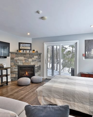 Interior view of a cozy vacation condo at Killington Center Inn and Suites with dining table and large windows.