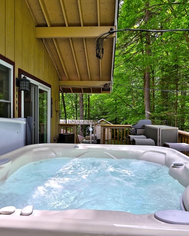 Deck of a cabin in Vermont with a hot tub.