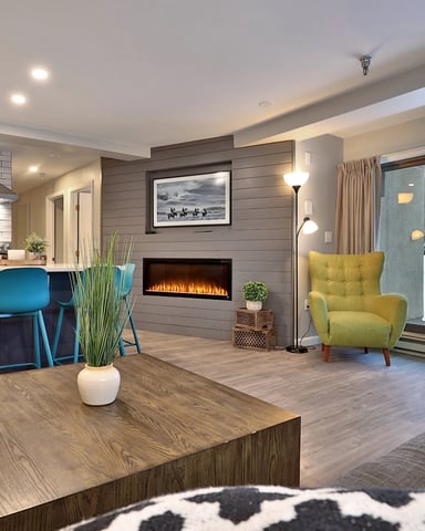 Stylish dining area and open kitchen in a vacation condo with a fireplace.