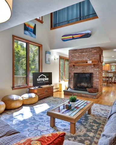 Large living room with brick fireplace and game room