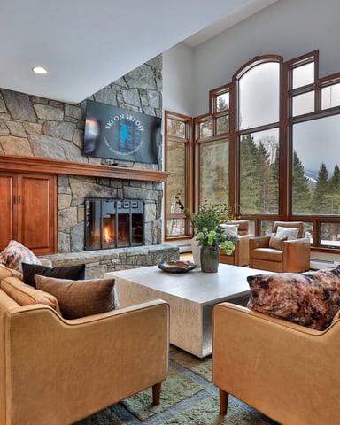 Spacious interior of a stylish Killington vacation home with leather armchairs and large windows.